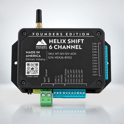 A black electronic module labeled 'Helix Shift 6 Channel' by Nomadic Controls, with a small antenna, terminal blocks in green and blue, and printed product details on the front against a light gray studio background.