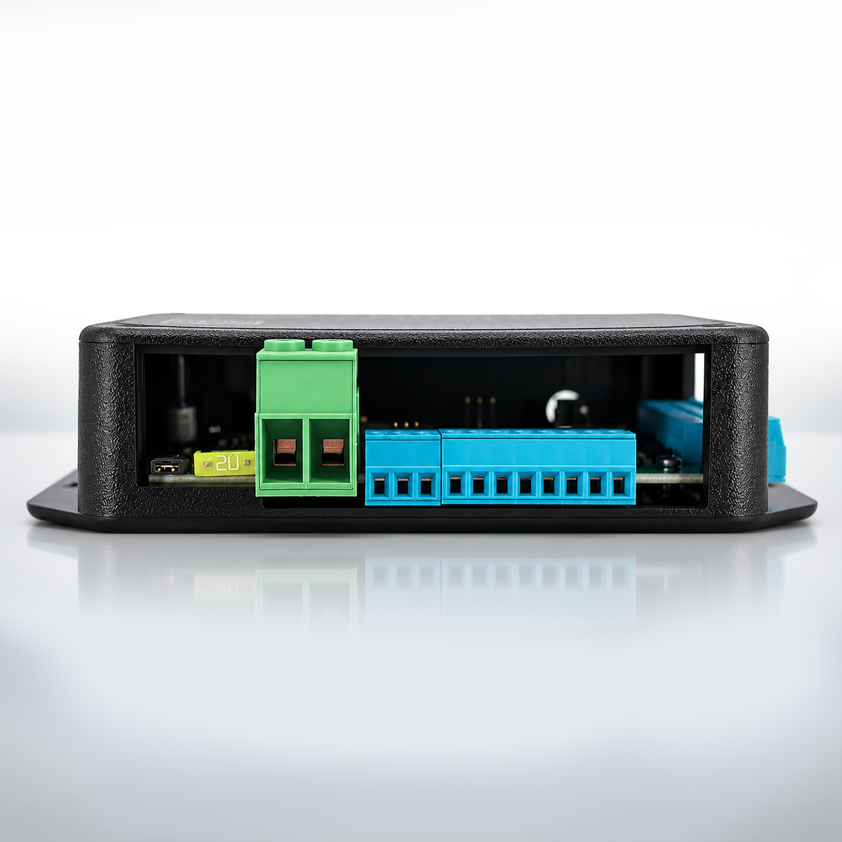A black industrial electronic module with a textured outer casing, showing a green terminal block and a blue connector strip on the open side panel, set against a clean white background with a soft reflection.