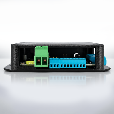 A black industrial electronic module with a textured outer casing, showing a green terminal block and a blue connector strip on the open side panel, set against a clean white background with a soft reflection.